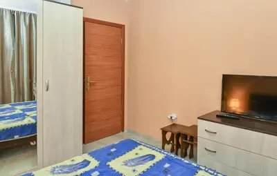 a bedroom with a bed and a flat screen tv at South Beach Vacation Apartments in Sunny Beach