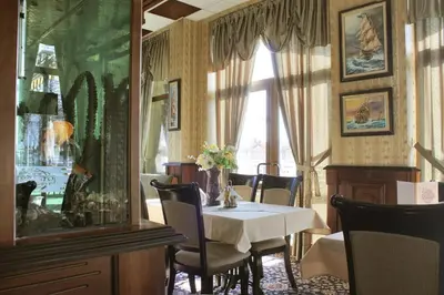 a dining room with a table and a fish tank at Hotel Dukov in Obzor