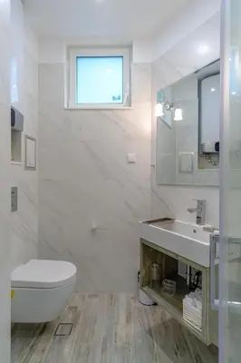 a white bathroom with a toilet and a sink at The Olive Green House - City Center - Free Parking in Burgas City