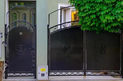 two black gates with hearts on them in front of a building at The Olive Green House - City Center - Free Parking in Burgas City