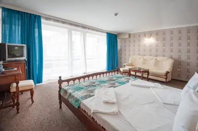 a bedroom with a bed and a couch and a television at Mercury Hotel- All Inclusive in Sunny Beach