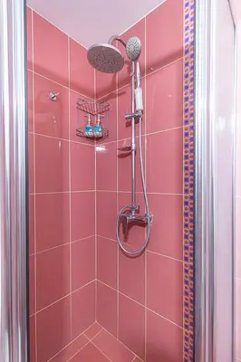 a shower with a red tiled wall at The Captain Be my guests! by RV Apartments in Varna City