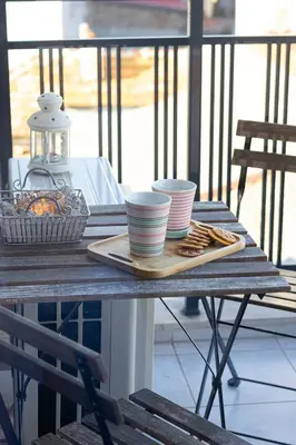 a table with a plate of food and cups on it at The Captain Be my guests! by RV Apartments in Varna City