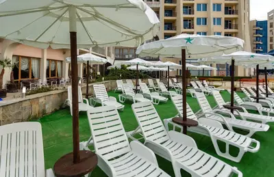 a group of chairs and umbrellas on a patio at Viand Hotel - All Inclusive in Sunny Beach