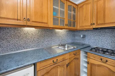 a kitchen with wooden cabinets and a sink at Family Hotel Argo in Varna City