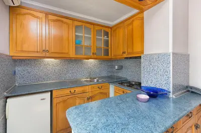 a kitchen with wooden cabinets and a blue counter top at Family Hotel Argo in Varna City