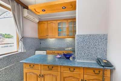 a kitchen with wooden cabinets and a blue counter top at Family Hotel Argo in Varna City
