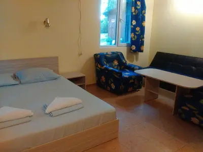 a bedroom with a bed and a chair and a table at Nimpha Bungalows in Kamchia