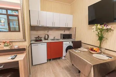 a kitchen with a table and a sink and a dishwasher at Deluxe Studios City Center in Burgas City