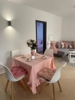a dining room table with a pink table cloth and chairs at PANTELI APART HOUSE in Aheloy