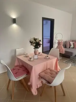 a dining room table with a pink table cloth at PANTELI APART HOUSE in Aheloy