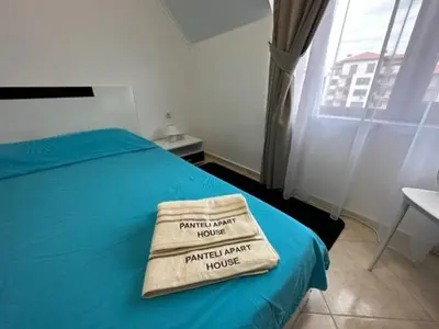 a bedroom with a blue bed with a towel on it at PANTELI APART HOUSE in Aheloy