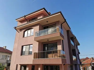a tall brick building with a balcony at Kazak in Obzor
