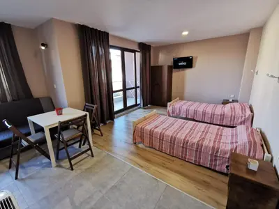 a room with a bed and a table and a couch at Kazak in Obzor