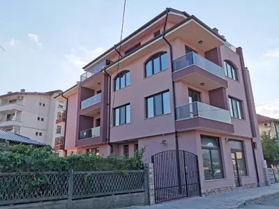a pink building with a fence in front of it at Kazak in Obzor