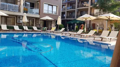 a large swimming pool with chairs and umbrellas at Apartman Horizont II - side sea view in Sozopol