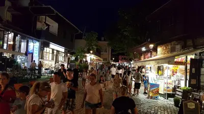 a crowd of people walking down a street at night at Apartman Horizont II - side sea view in Sozopol