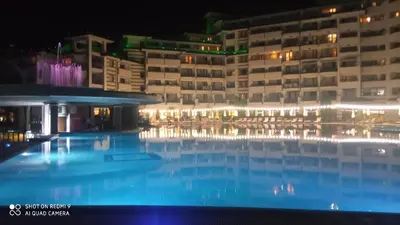 a large swimming pool in front of a building at night at Emerald Beach Resort & Spa,studio ikat310 in Ravda