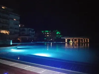 a swimming pool at night with blue lights at Emerald Beach Resort & Spa,studio ikat310 in Ravda