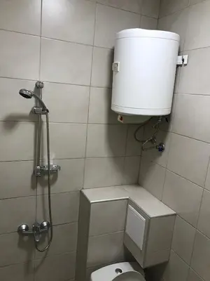 a bathroom with a toilet and a water tank at Студио Чайка Бургас Център in Burgas City