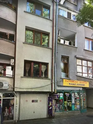 a tall building with a store in front of it at Студио Чайка Бургас Център in Burgas City