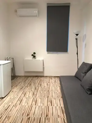 a living room with a couch and a blackboard on the wall at Студио Чайка Бургас Център in Burgas City
