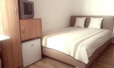 a small bedroom with a bed with a tv on it at SUNRISE 2 in Varna City