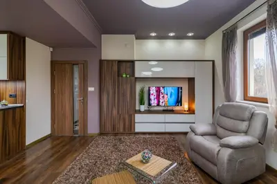 a living room with a chair and a television at Cosy Luxury Flat in the Centrum- 90sqm - 3 rooms. in Varna City