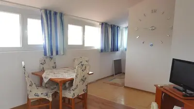 a dining room with a table and chairs and a clock at Beautiful Penthouse Apartment in Sunny Beach