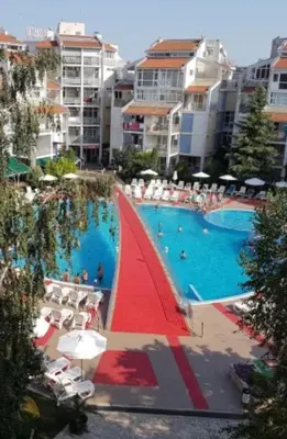 a large swimming pool with a red sail boat in it at Beautiful Penthouse Apartment in Sunny Beach
