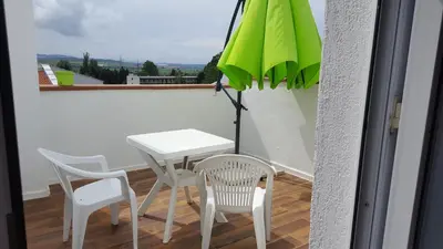 a white table and chairs and an umbrella on a balcony at Beautiful Penthouse Apartment in Sunny Beach