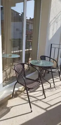 a glass table and two chairs on a balcony at MIDA Apartment in Obzor