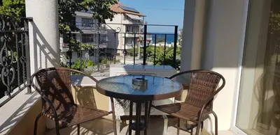 a table and chairs on a balcony with a view of the ocean at MIDA Apartment in Obzor