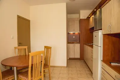 a kitchen with a table and chairs and a refrigerator at Prestige City 1BD Apt with POOL near to Cacao Beach by Flаt Manаger in Sunny Beach