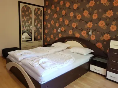 a bedroom with a bed with white sheets and a mirror at Апартамент Емилия in Sozopol