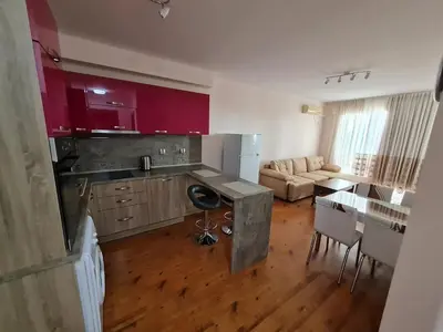 a kitchen and living room with red cabinets and a table at MitProt Panorama Bay 2 luks Apartment 173 in Sveti Vlas
