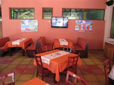 a restaurant with tables and chairs and a tv at Maverick Hotel in Sunny Beach