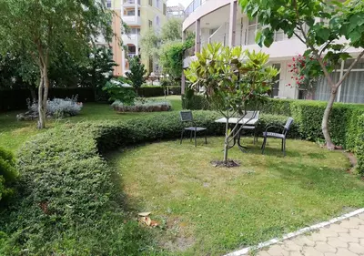 a park with chairs and a table and a tree at Charis Cozy Family apart at Sun Village Complex close to the Beach in Sunny Beach