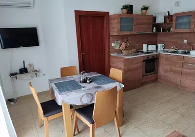 a kitchen with a table and chairs in a room at Charis Cozy Family apart at Sun Village Complex close to the Beach in Sunny Beach