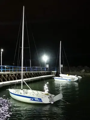two boats are docked in the water at night at Ferano Beach Apartments in Nesebar