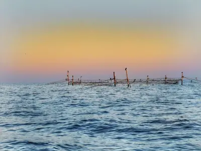 a pier in the middle of the water at sunset at Ferano Beach Apartments in Nesebar