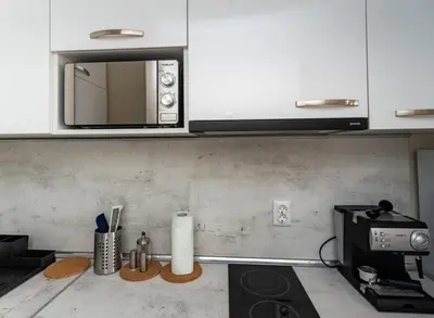 a kitchen with white cabinets and a microwave at Apartment Galia in Burgas city center in Burgas City