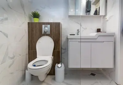 a white bathroom with a toilet and a sink at Apartment Galia in Burgas city center in Burgas City