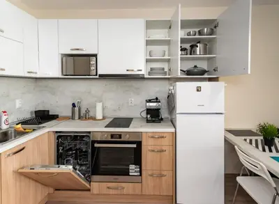 a kitchen with white cabinets and a white refrigerator at Apartment Galia in Burgas city center in Burgas City