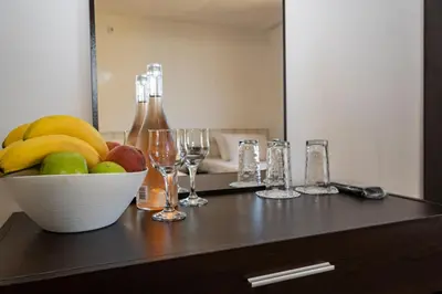 a table with a bowl of fruit and wine glasses at Guest House Elidis in Primorsko