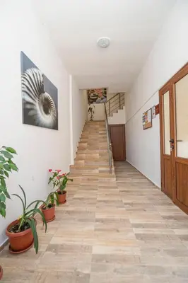 a hallway with stairs and potted plants in a building at Guest House Elidis in Primorsko