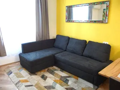a blue couch in a living room with a mirror at San Stefano Elite Apartment in Varna City