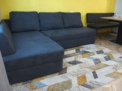 a blue couch in a living room with a rug at San Stefano Elite Apartment in Varna City