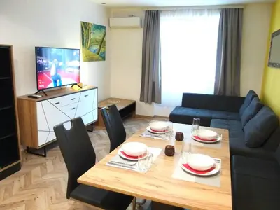 a living room with a table and a couch at San Stefano Elite Apartment in Varna City