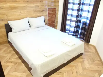 a bedroom with a bed with white sheets and a window at San Stefano Elite Apartment in Varna City